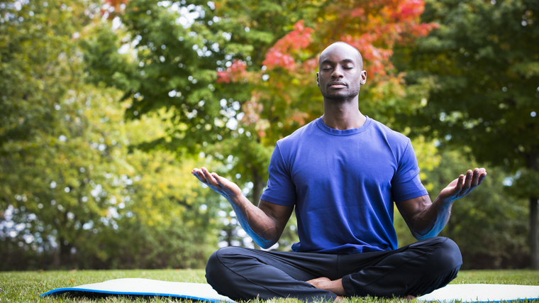 A person performing yoga or meditation in a peaceful setting